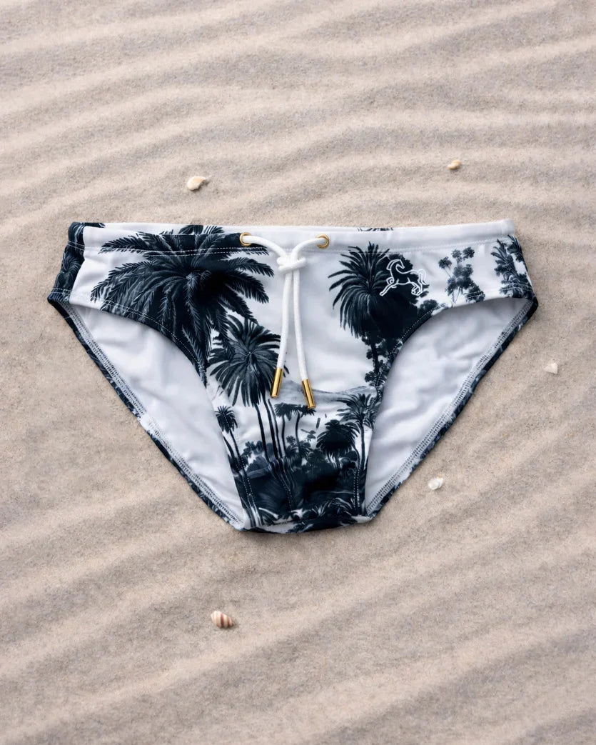 Black jungle swim brief with tropical palm tree print, low-rise fit, recycled fabric, designed & made in Australia.