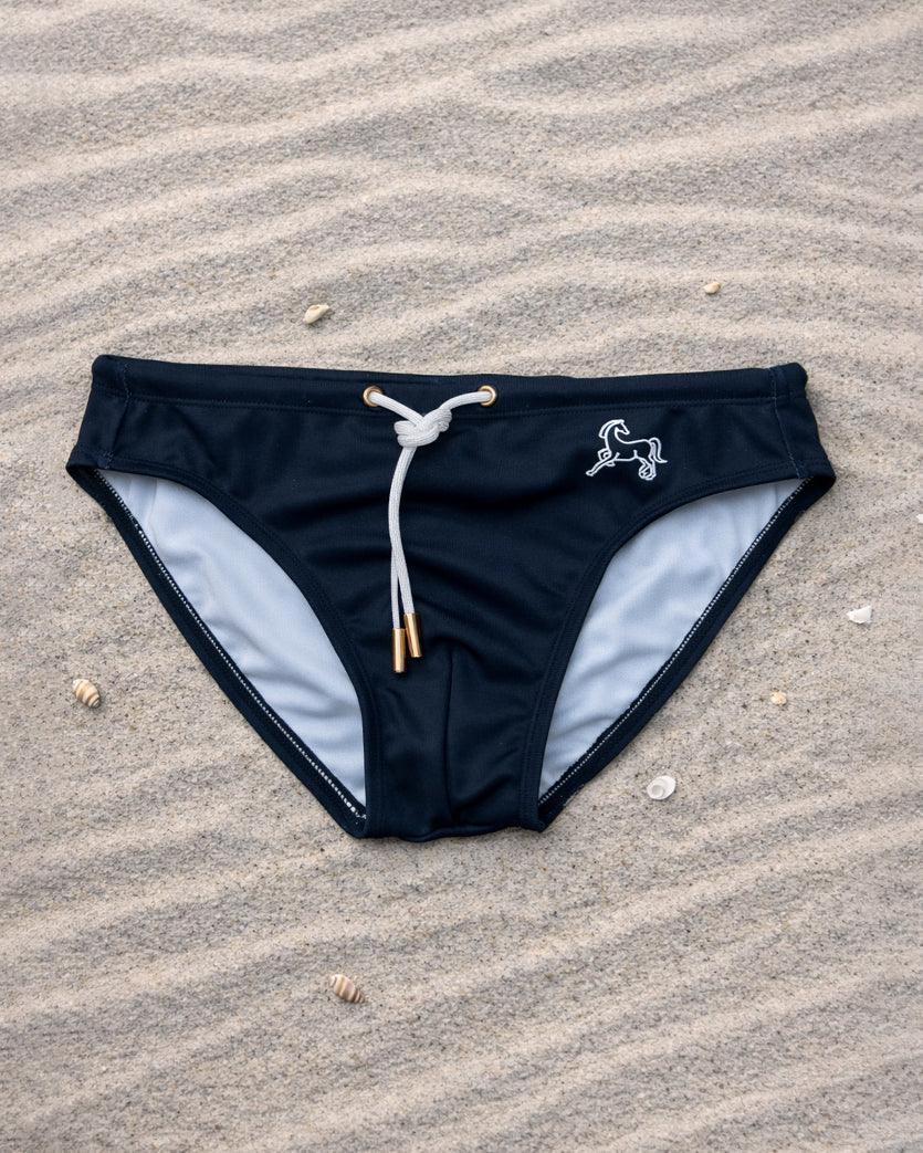 Black swim brief front view with white drawstring and lining, low-rise fit, recycled stretch fabric, designed and made in Australia